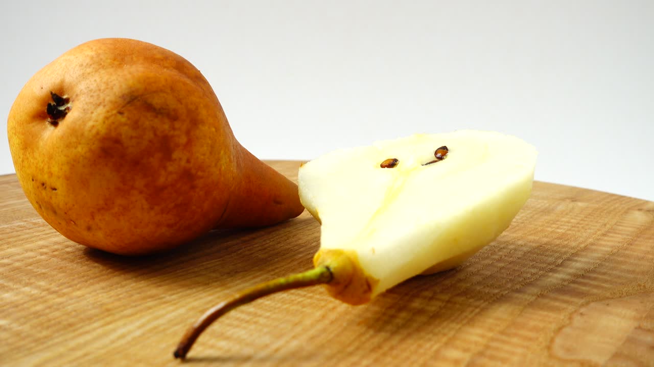 Pere su un tagliere di legno in cucina. Ripresa in movimento