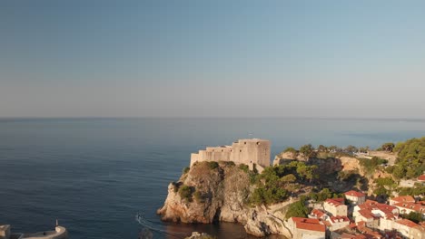 Walled-city-of-Dubrovnik-in-a-warm-morning-light,-an-aerial-panorama-over-red-rooftops,-ancient-wall,-and-fortress-Lovrijenac