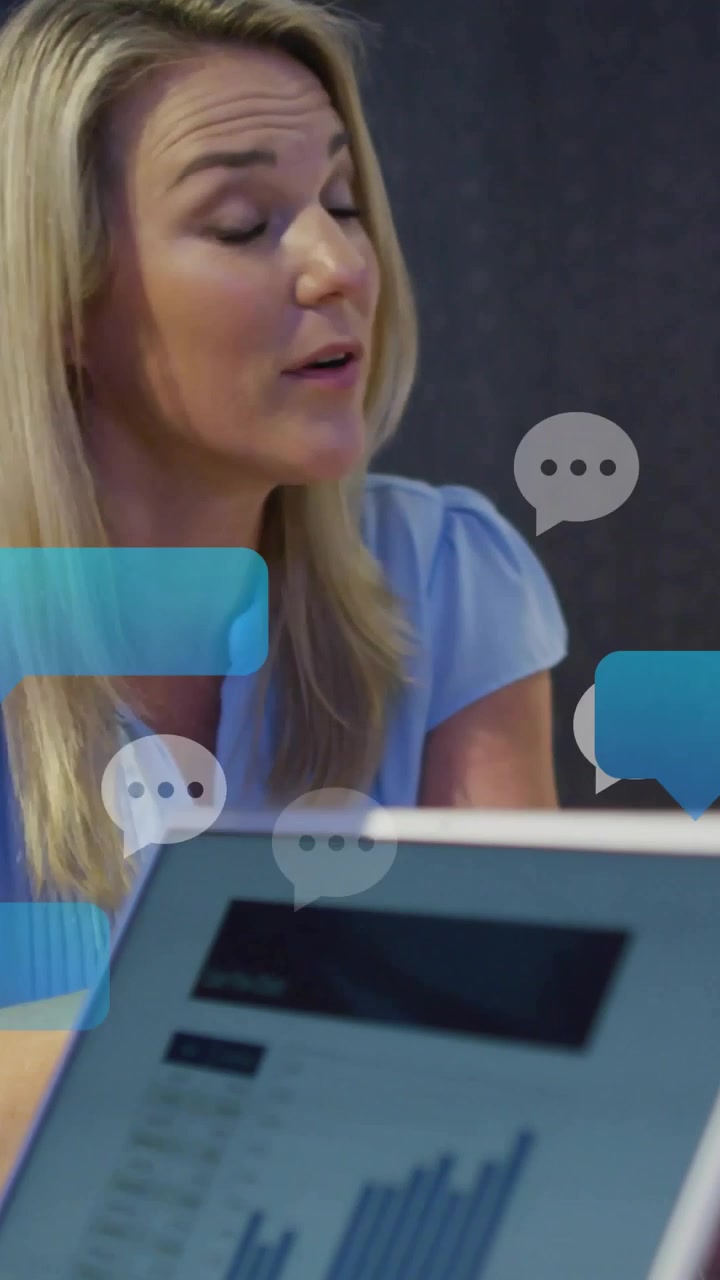 Video verticale: Donna che visualizza un grafico sul PC con documenti aziendali, con icone di chat che si ingrandiscono mentre parla.