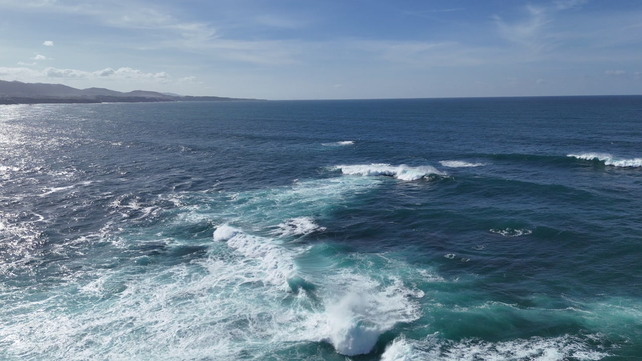 Wide drone shot of rolling Atlantic swell and white foam patterns across open blue water.