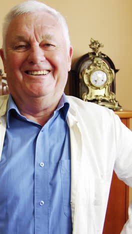 portrait of smiling horologist standing with arms crossed