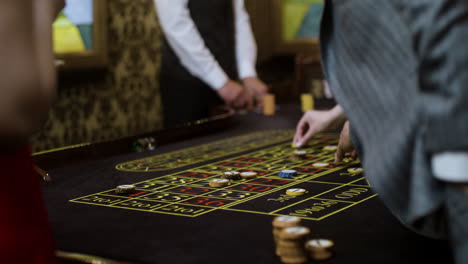 group of multiethnic players placing bets at roulette table.