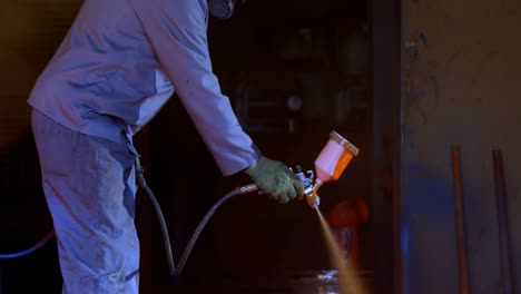 metalsmith using spray painting machine in workshop 4k