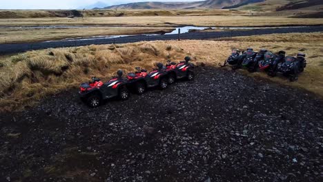 Aerial-view-of-red-quad-bikes-parked-on-black-sand-in-Iceland-highlands