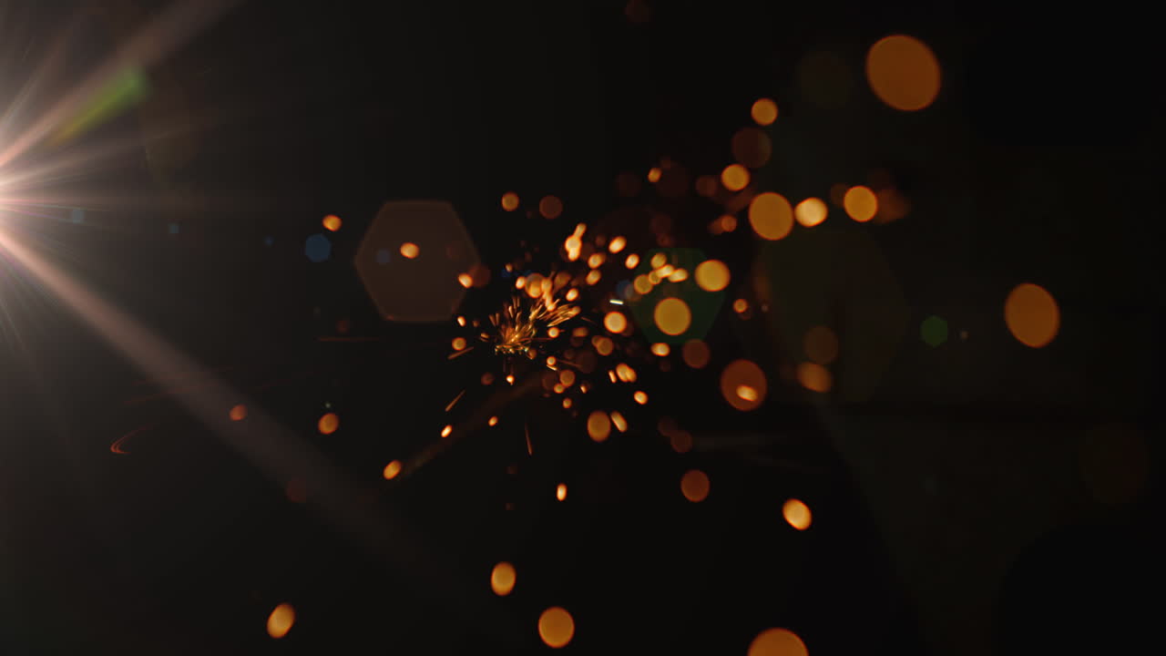Orange sparks of light against black background