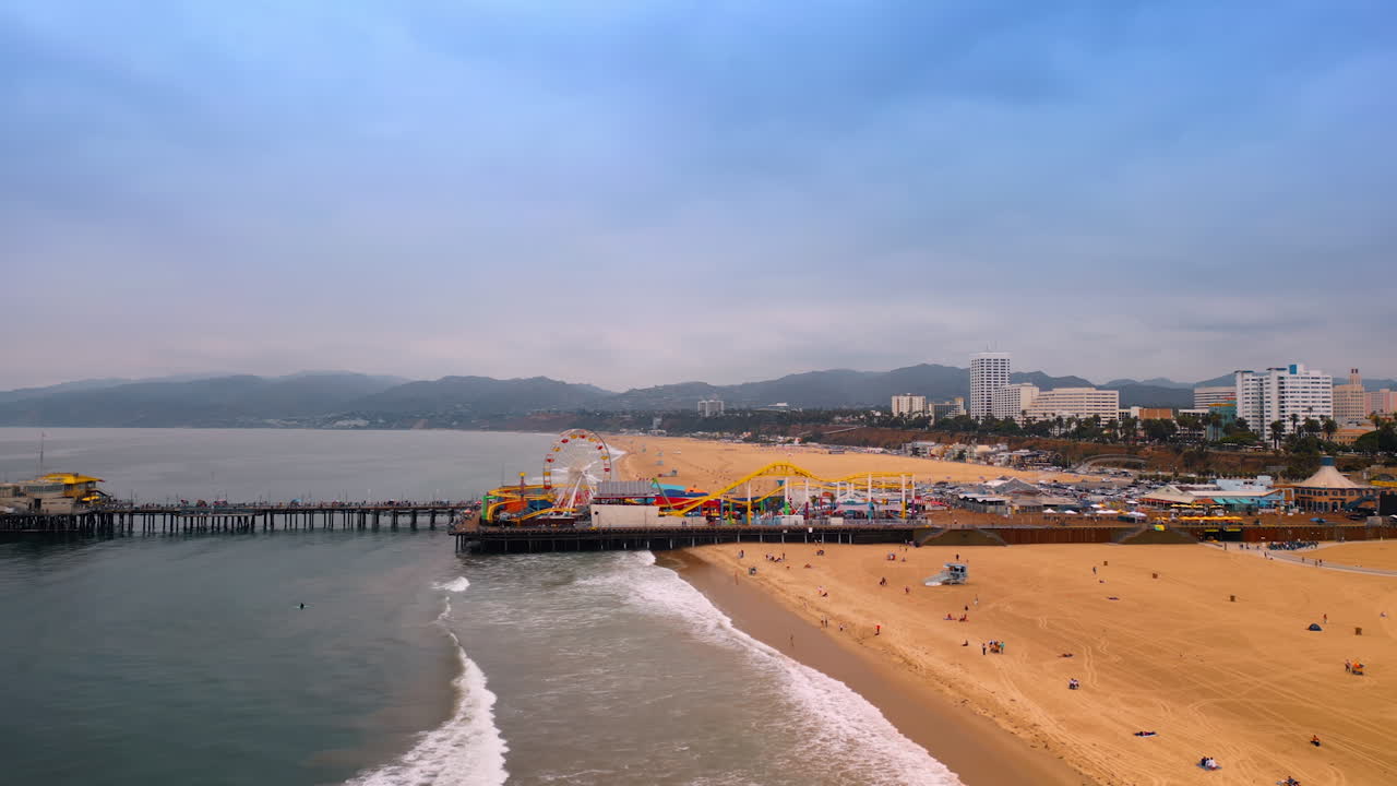 Approaching Santa-Monica Piers with an amusement park. View on the Pacific Park on gloomy day