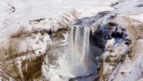 Tomas-Aéreas,-Cinematográficas,-Dramáticas-Y-únicas-Con-Drones-En-4k-De-Una-Cascada-De-Kirkjufellsfoss-Rodeada-Por-La-Formación-Escénica-De-Rocas-Cubiertas-De-Nieve