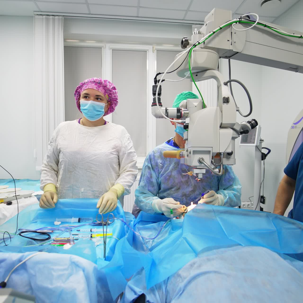 Cataract operation in modern ophthalmic clinics. Two male surgeons and female nurse conducting eyesight surgery