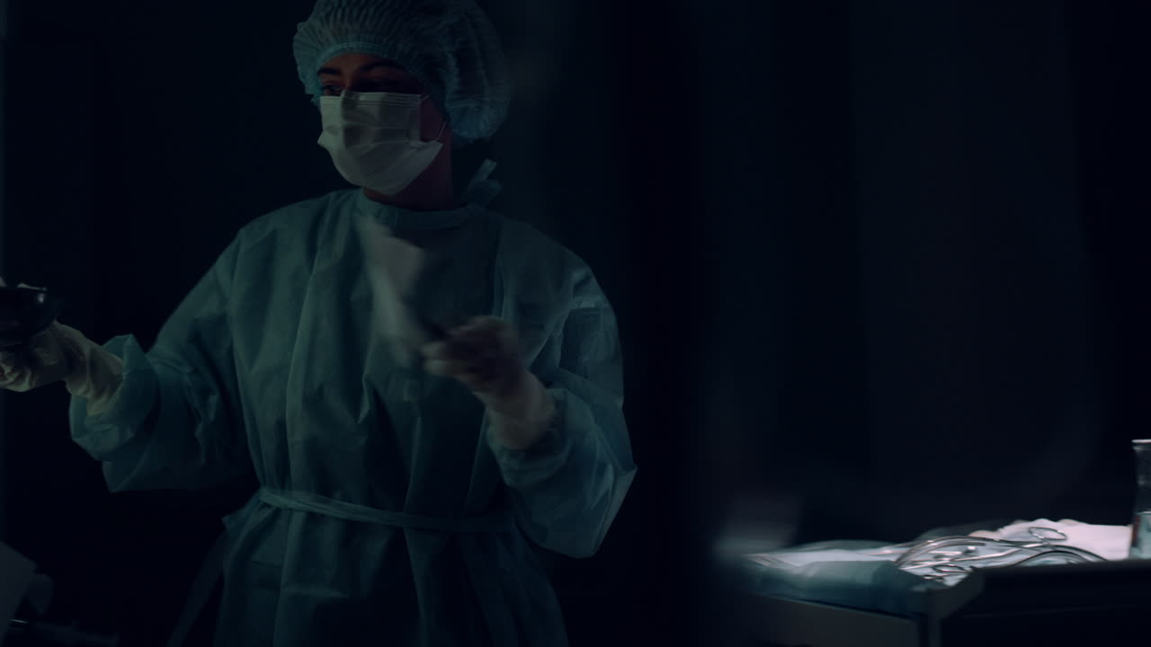 Infermiera che assiste un chirurgo che impugna strumenti chirurgici in un reparto clinico.