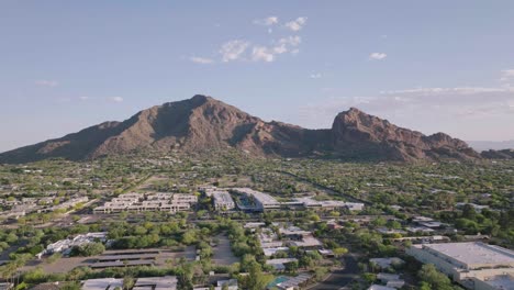 Aerial-tilt-up-shot-of-Paradise-Valley-in-Arizona,-looking-at-camelback-mountain-on-a-clear-sunny-day-in-USA