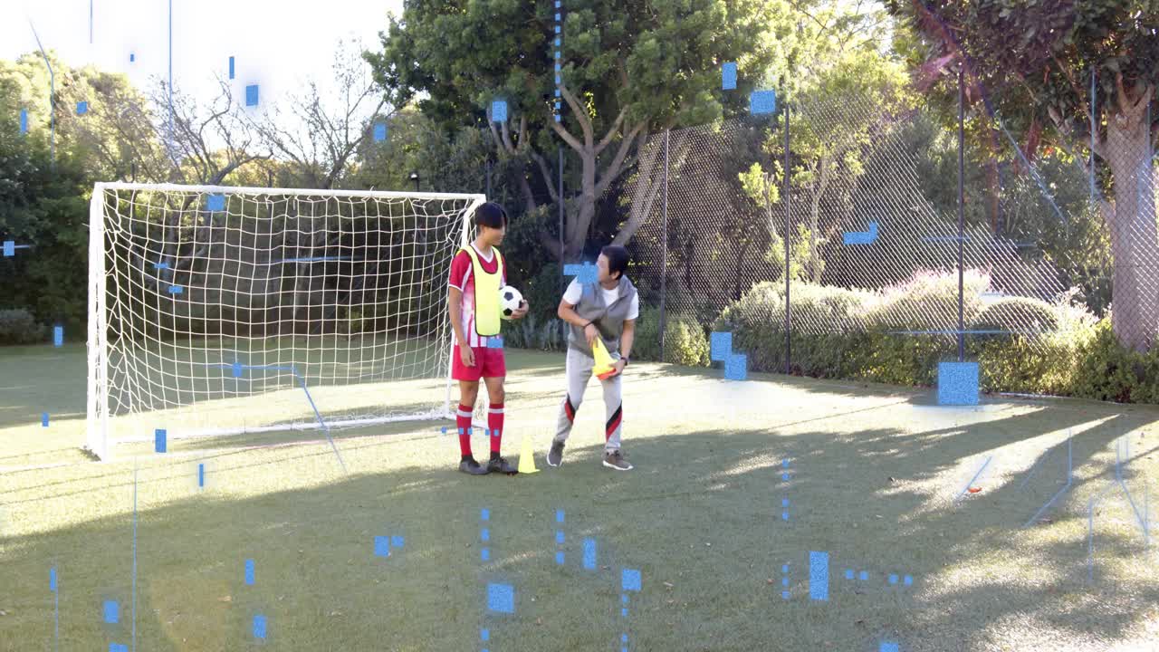 Coach walking toward player and initiating cone setup, placing cones on turf near goal for training