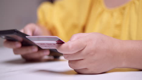 close-up of an individual encoding some information of a credit card for an online business transaction