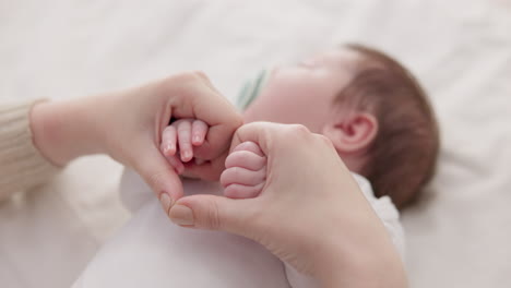 bed, holding hands and mother with baby