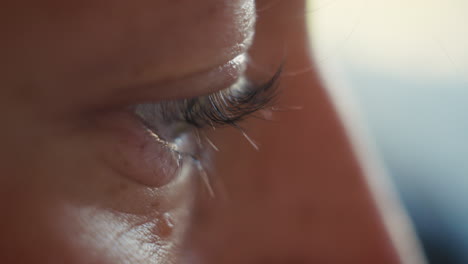 extreme close-up of a person's eye, showcasing long eyelashes and the intricate details of the iris and skin texture