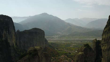 aerial view in middle of sandstone pillars in meteora, greece - reverse, tilt, drone shot