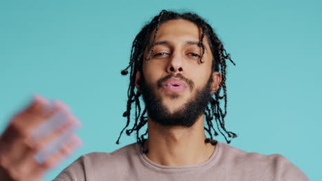 Man-blowing-kisses-to-camera,-being-flirty,-studio-background