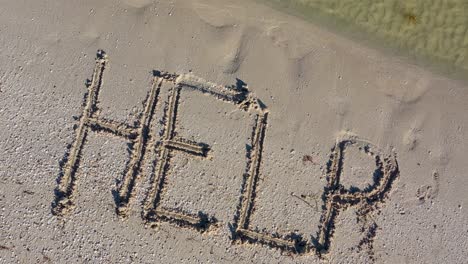 Die-In-Den-Sand-Geschriebene-Hilfe-Wird-Größer