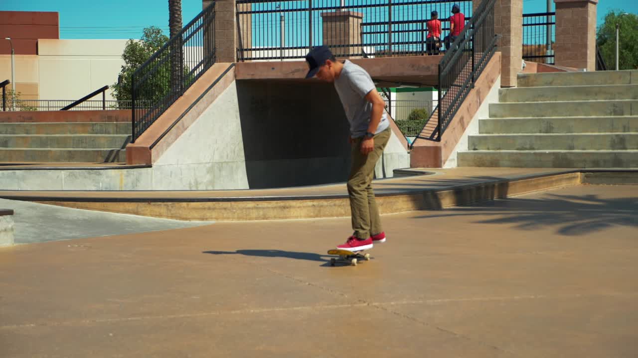 toma en cámara lenta de un joven patinador montando patineta en el parque de patinaje realizando un truco