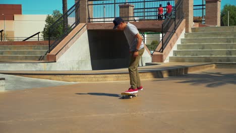 slow motion shot of young male skateboarder riding skateboard at skate park performing a trick