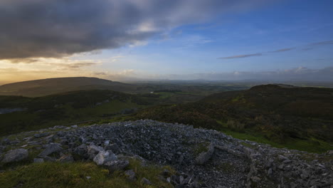 Zeitraffer-Einer-Ländlichen-Naturlandschaft-Mit-Ruinen-Prähistorischer-Ganggrabsteinblöcke-Im-Vordergrund-Während-Eines-Sonnigen,-Bewölkten-Abends,-Gesehen-Von-Carrowkeel-In-Der-Grafschaft-Sligo-In-Irland