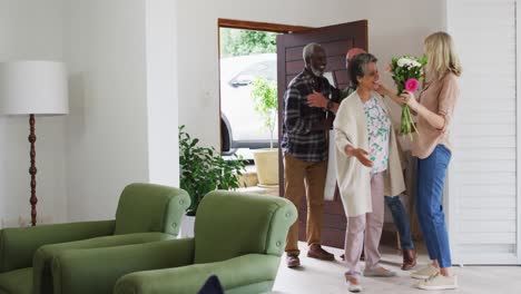 Two-diverse-senior-couples-hugging-and-greeting-each-other-at-home