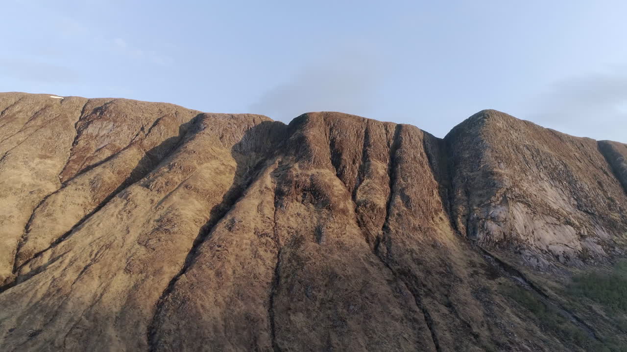 la luz del sol ilumina la cresta de una montaña en glencoe, tierras altas escocesas