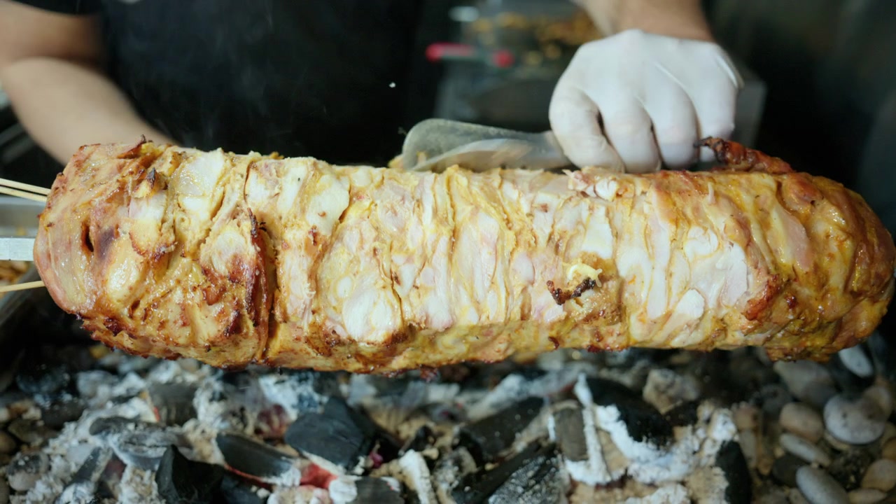Spiedino di tradizionale cag kebab turco che cuoce lentamente su carboni ardenti, creando delizioso cibo da strada.