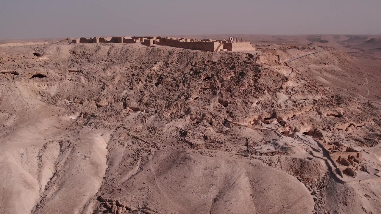Vista aerea di antiche rovine in pietra su una collina desertica rocciosa