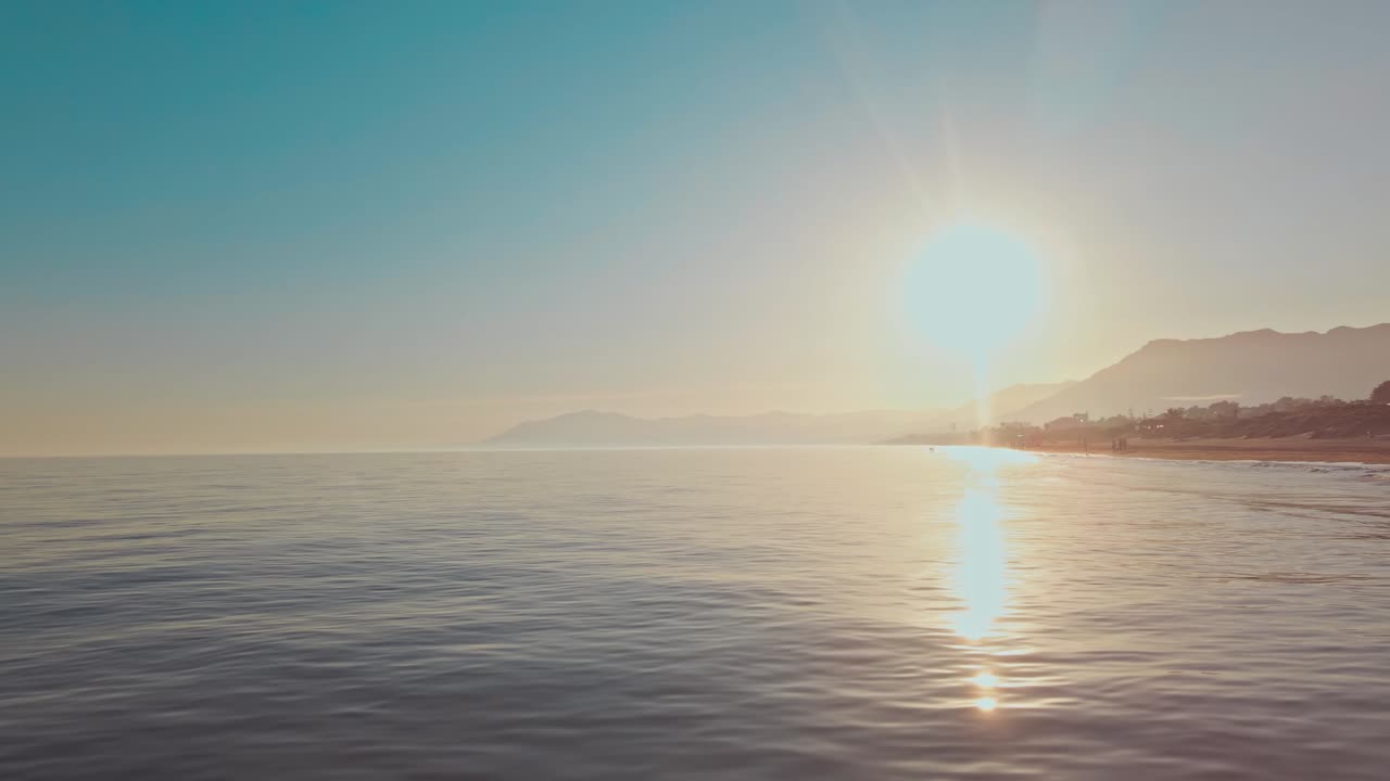 Slow left panning movement from the beach coastline into the ocean