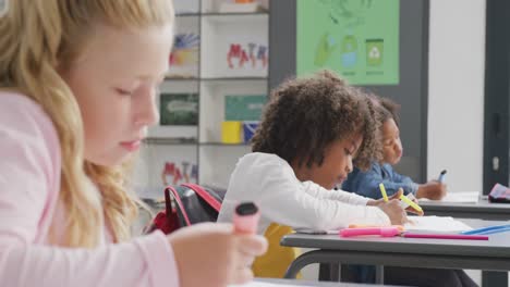 Video-De-Un-Colegial-Afroamericano-Sonriente-Trabajando-En-Un-Escritorio-En-Una-Clase-Escolar-Diversa