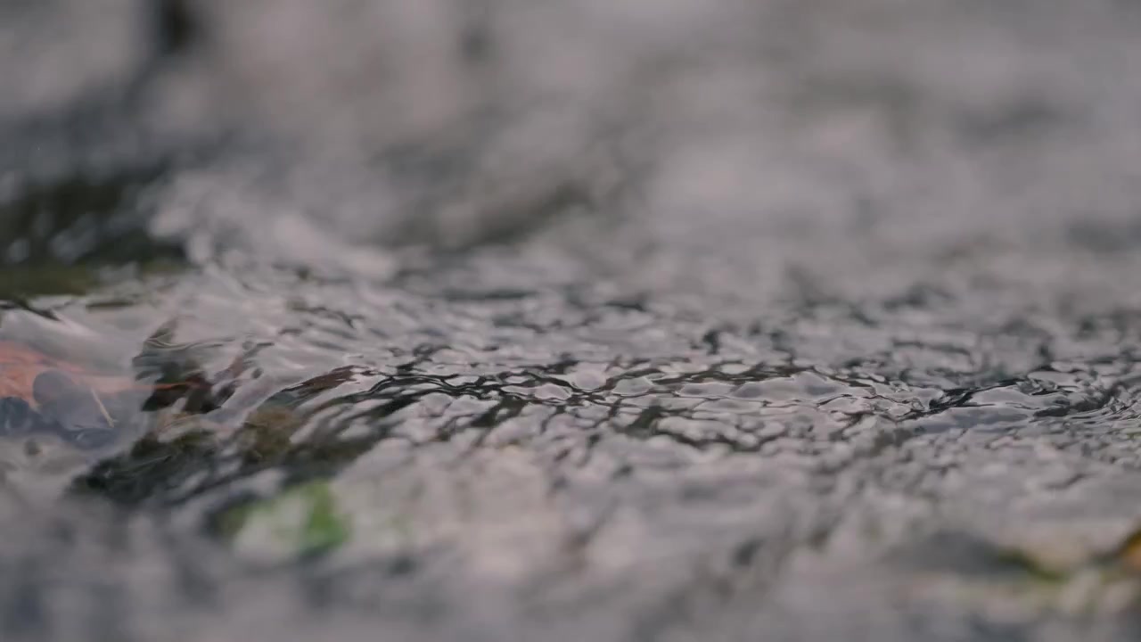 小川の岩の上を流れる透き通った水のクローズアップ