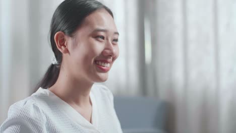 웃는 아시아 여성 엔지니어와 집 모델이 집에서 데스크에서 일하는 클로즈업