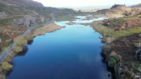 Reveladora-Toma-De-Drone-De-La-Brecha-Entre-Dunloe,-Irlanda-Y-El-Río-Loe,-Con-Una-Carretera-En-La-Orilla.