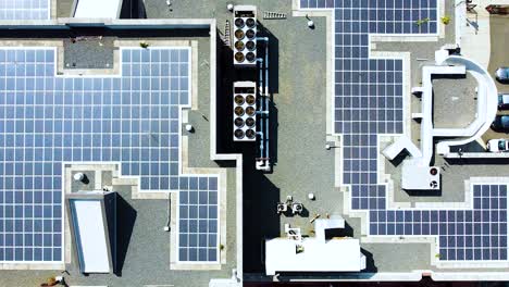 left to right aerial flyover of solar panel array on top of building