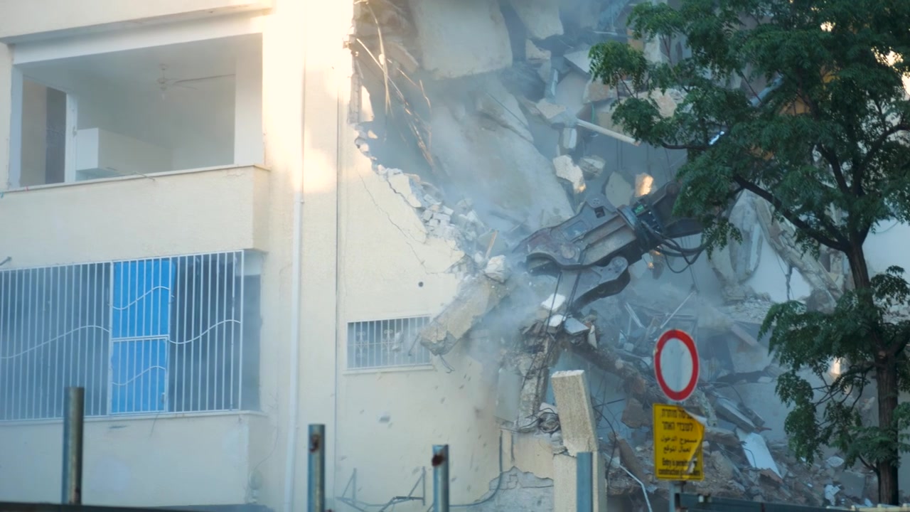 Dettagli ravvicinati seguono la gru compattatrice di demolizione di edifici con escavatore durante un progetto di riqualificazione urbana.