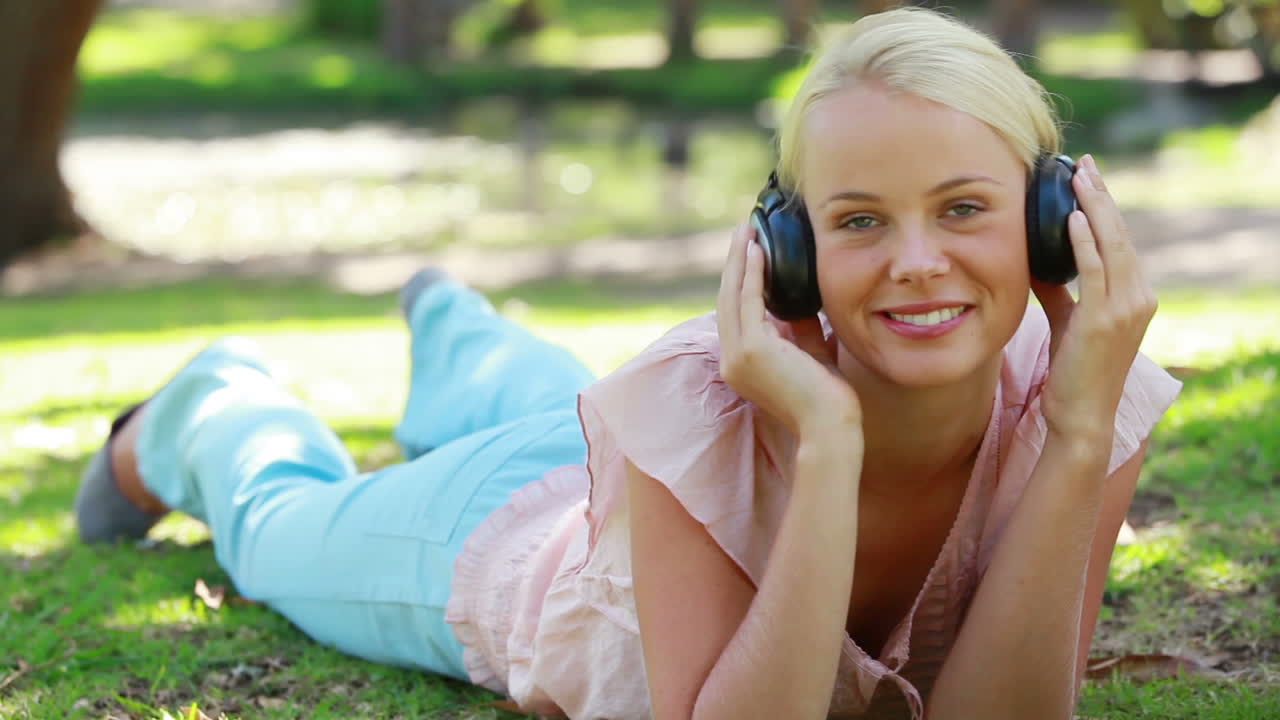 헤드폰을 들고 음악을 듣는 소녀에 초점을 맞춘 비디오
