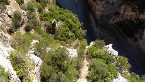 couple sits on the edge of the osumit canyon