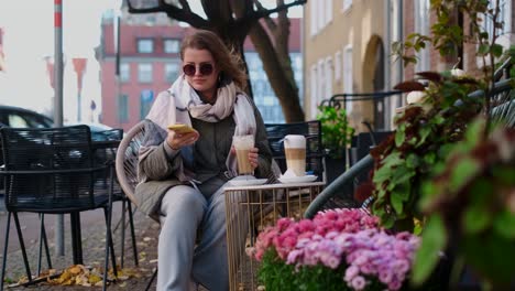 woman enjoying coffee and phone in an autumn cafe
