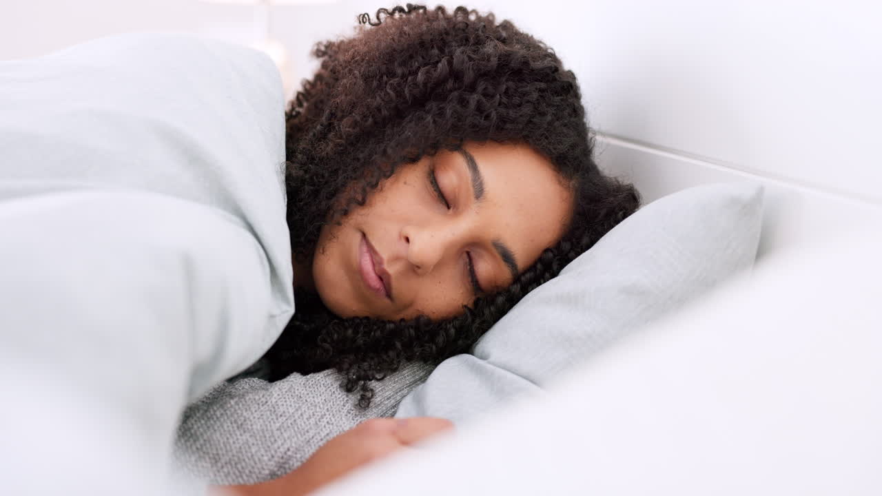 joven negra durmiendo en la cama en su dormitorio