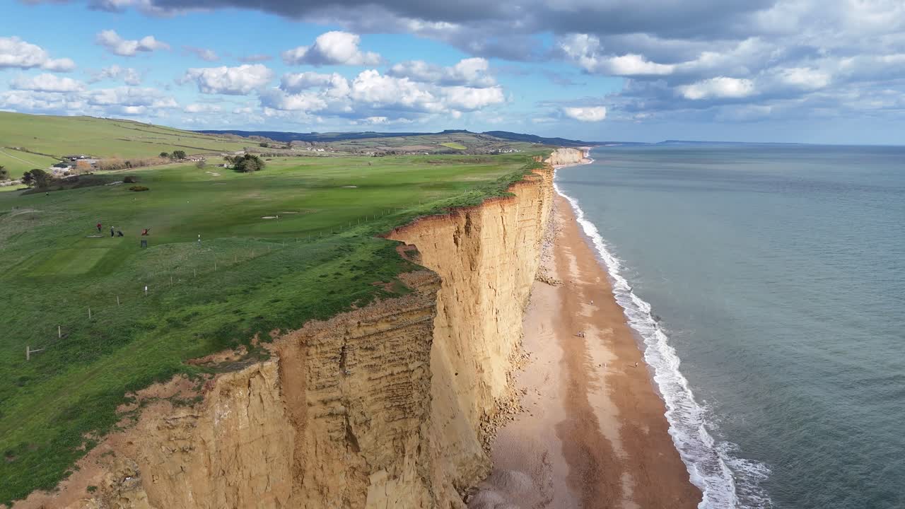 Scogliere rosse sul mare a West Bay, Dorset, Regno Unito, vista aerea con drone.