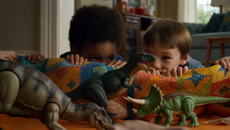 two young boys playing with toy dinosaurs