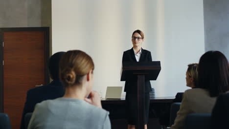 白人女性演講者在台上在會議上發表演講,並回答觀眾的問題