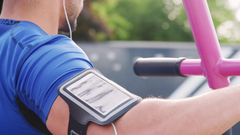 joven atleta masculino que utiliza gimnasio al aire libre, sección media