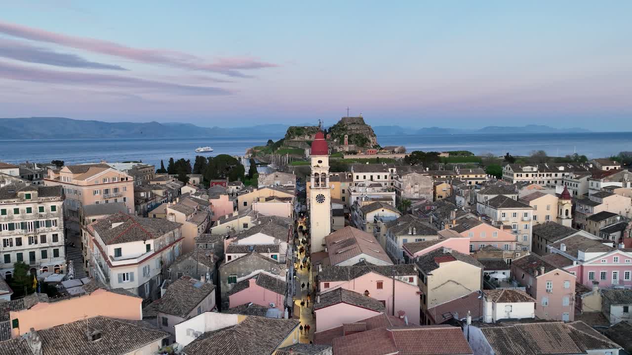 Veduta aerea del centro storico di Corfù e del campanile della chiesa di San Spiridione al crepuscolo, con la Vecchia Fortezza sullo sfondo, Grecia.