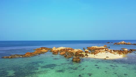 Tropical-sandbank-with-granite-rocks,-aerial-background