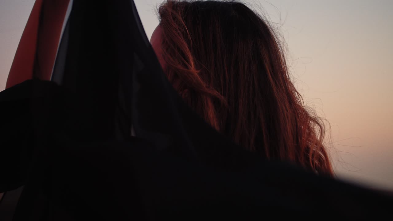 그녀의 얼굴을 초점으로 드러내는 아라비아 여성의 중간 샷을 추적하여 힘과 생산성, 아라비아 사막 화석 언덕을 보여줍니다.