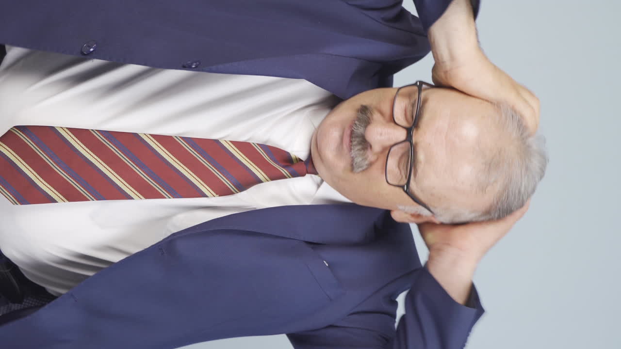 신경 ⁇ 약을  ⁇ 고 있는  ⁇ 은 사업가의 수직 영상입니다.