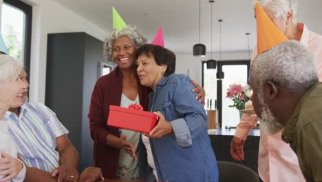 Happy-senior-diverse-people-at-birthday-party-with-cake-and-gifts-at-retirement-home