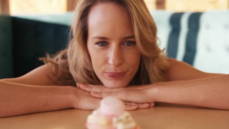 woman looking at cupcake in cafe