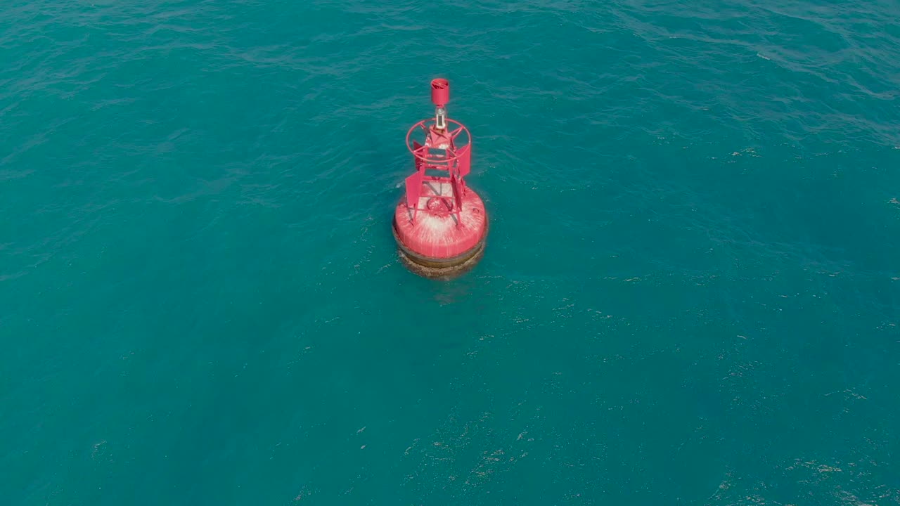 Aerial shot of a red buoy in a beautiful blue sea